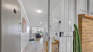 A modern interior with a wooden floor, a cactus, and a number '6' sign.