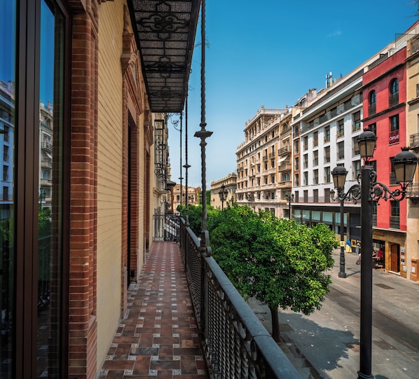 Uma passagem de pedestres estreita com piso de azulejos, ladeada por edifícios com arquitetura tradicional e um céu azul claro.
