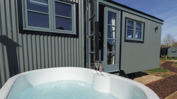 Un jacuzzi frente a un edificio metálico con ventanas.