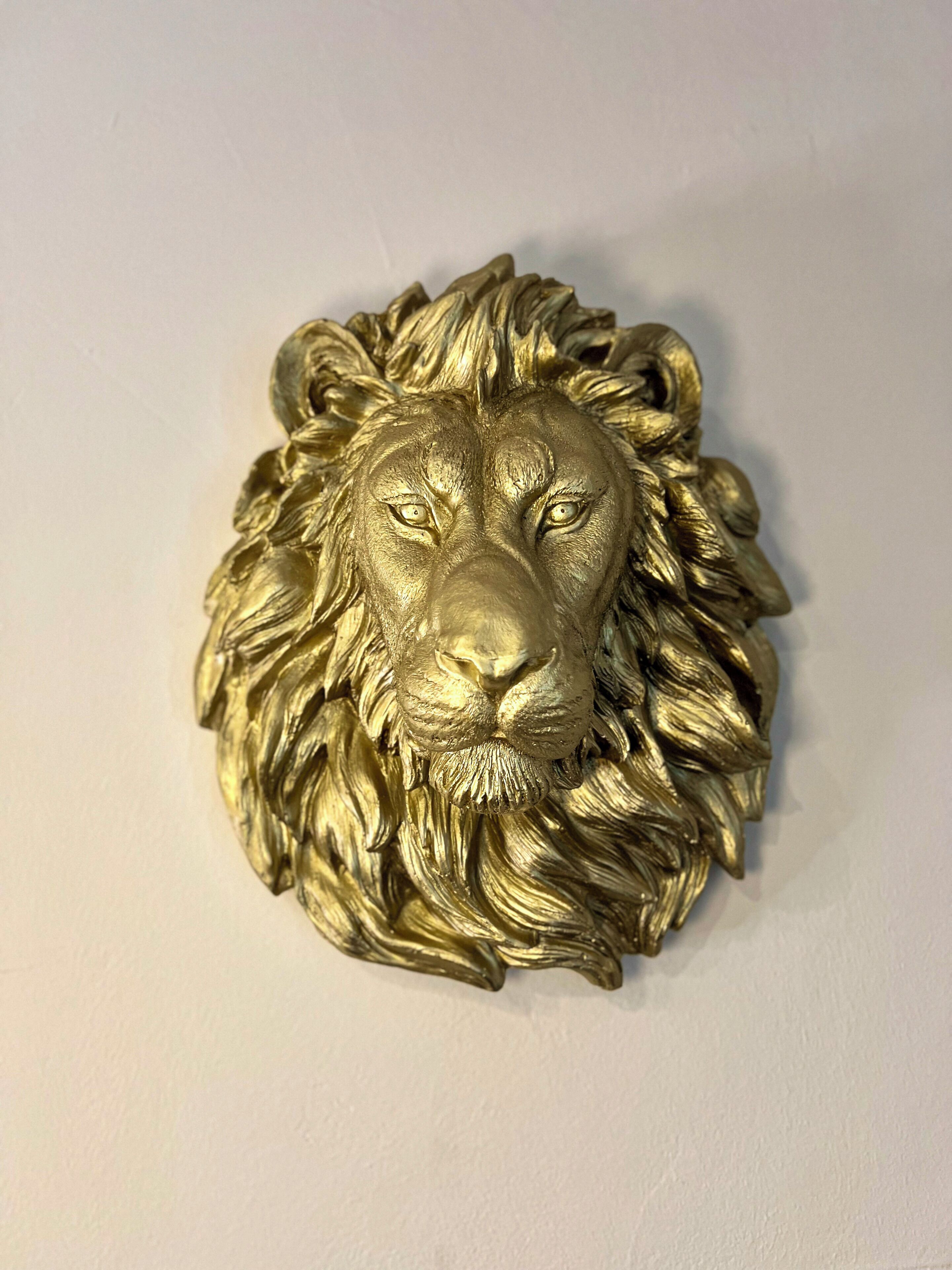 Kultainen leijonanpääveistos.