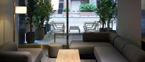 Ein modernes Interieur mit einer Couch, einem Couchtisch und Blick auf die Straße.