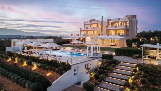 A modern multi-story house with a swimming pool, outdoor seating, and well-lit pathways. - Ema's Guest House (Markopoulo Mesogaias)
