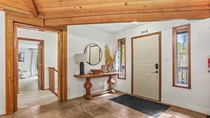 A wooden-floored hallway with a door marked "EXIT" and a mirror above a console table.
