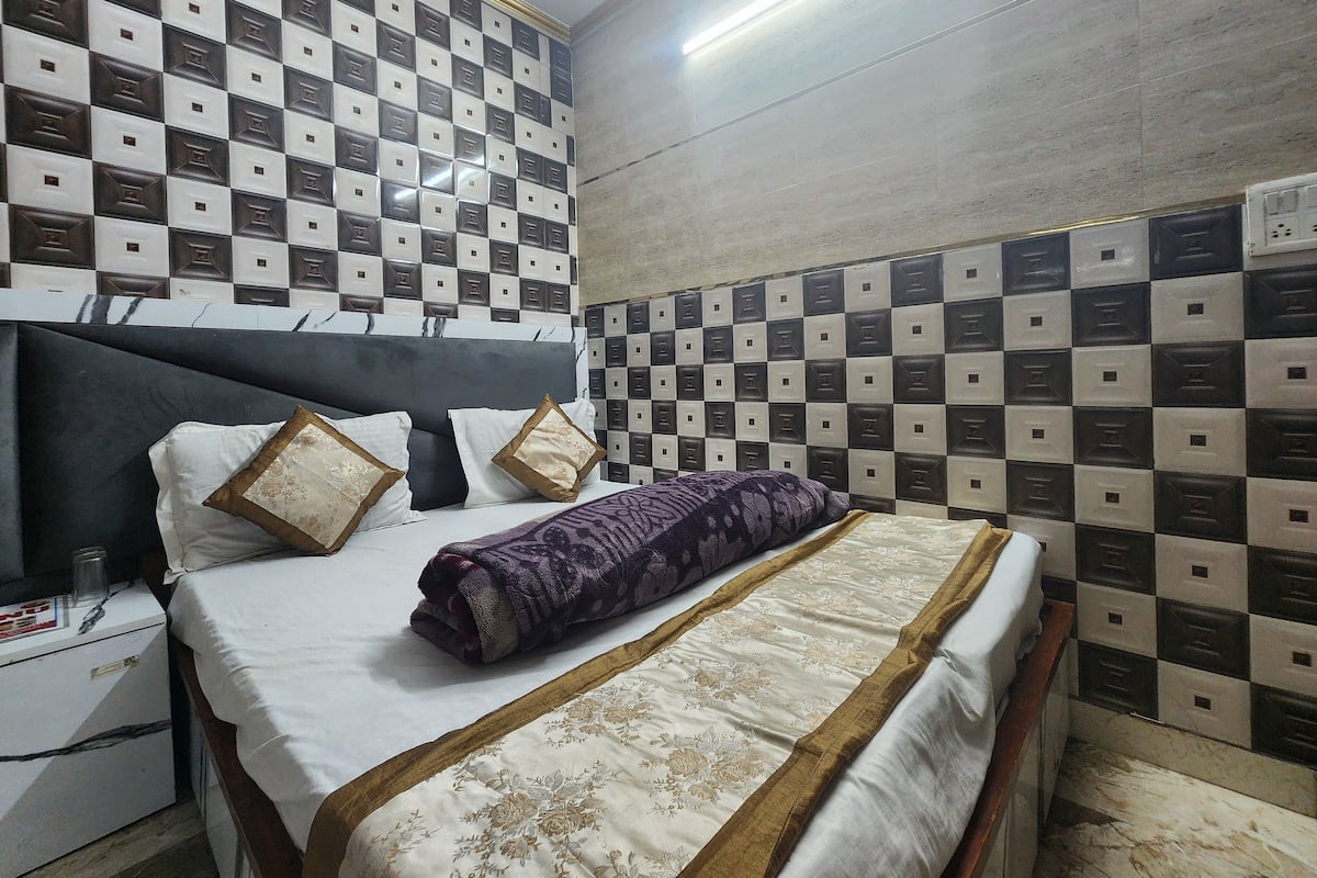 Una cama bien hecha con una colcha estampada, un cabecero y almohadas.