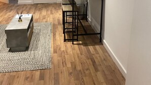A compact kitchen with a microwave, a small table, and a bench.