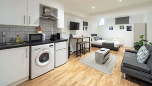 A modern apartment with a kitchen, a dining area, and a living room.