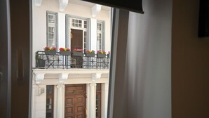 Un bâtiment doté d’un balcon, d’une porte en bois et d’une fenêtre.