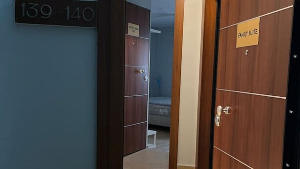 A hotel corridor with a wooden door labeled "Family Suite" and a staircase leading to another room. - Aristidou 10 Suite by Zeus suites (Athina)