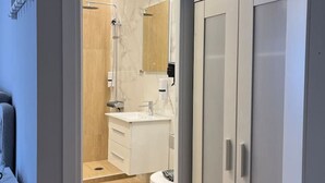 A modern bathroom with a shower, toilet, and vanity. - Aristidou 10 Suite by Zeus suites (Athina)