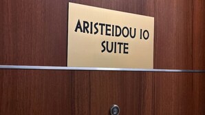 A wooden panel with a sign reading "ARISTEIDOU IO SUITE". - Aristidou 10 Suite by Zeus suites (Athina)