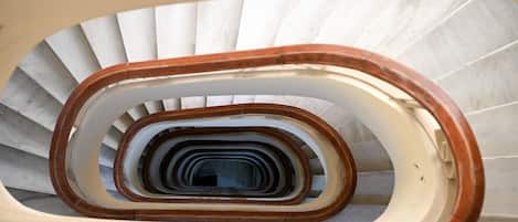 A spiral staircase with wooden handrails and white steps.