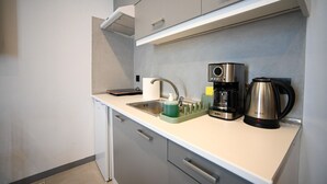 Une cuisine moderne équipée d’un évier, d’une machine à café et d’une bouilloire.