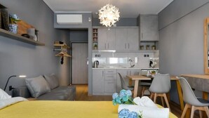 A modern, compact living space with a kitchenette, a dining area, and a seating area.