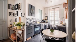 A modern kitchen with a stove, oven, and dining table. - Playful Atelier, by Veeve (Paris)