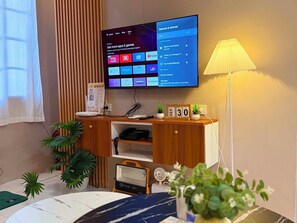 Una sala de estar moderna con un televisor de pantalla plana montado en la pared mostrando la pantalla de inicio.