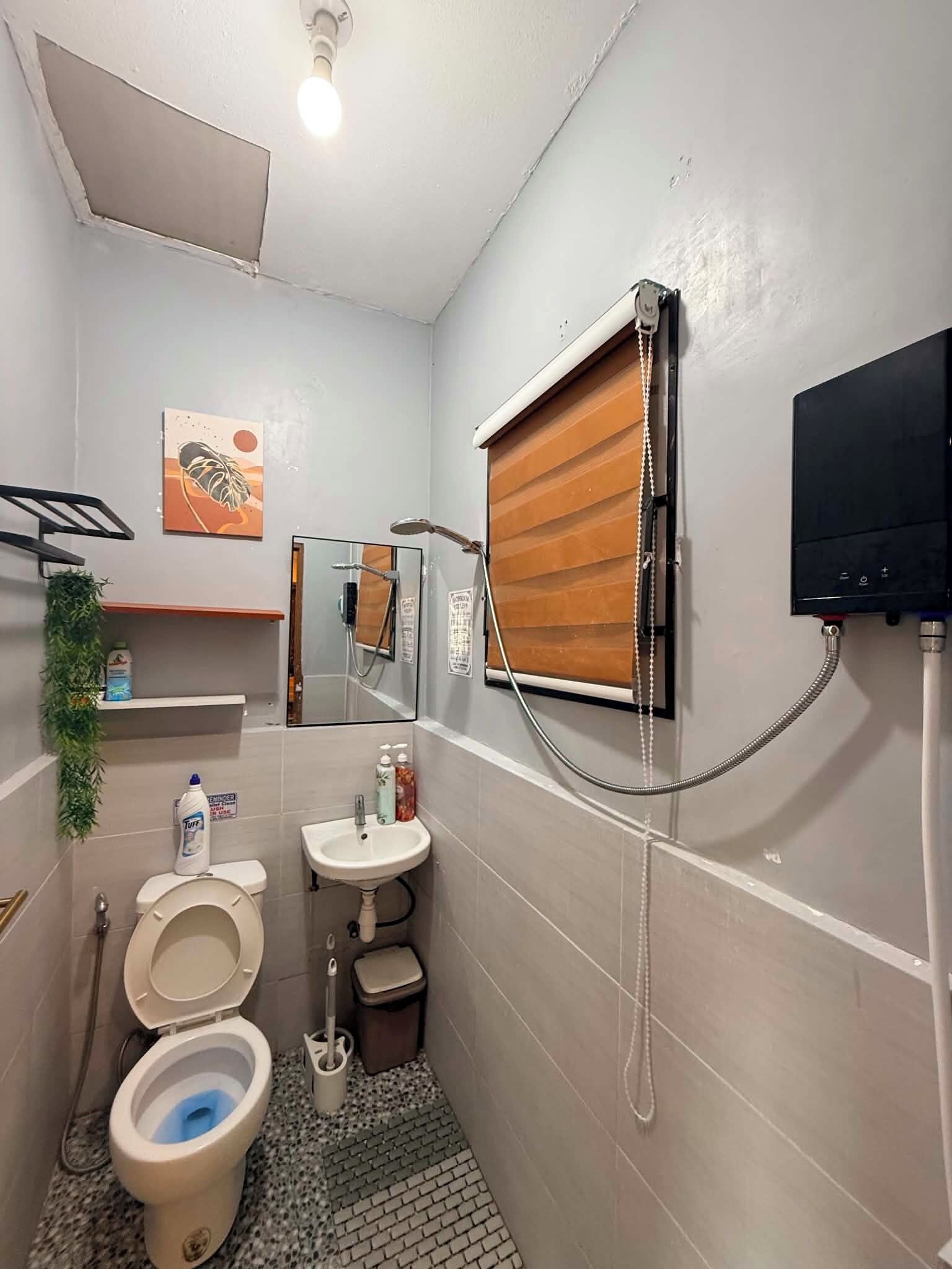 Un baño pequeño con inodoro, lavamanos y ducha.