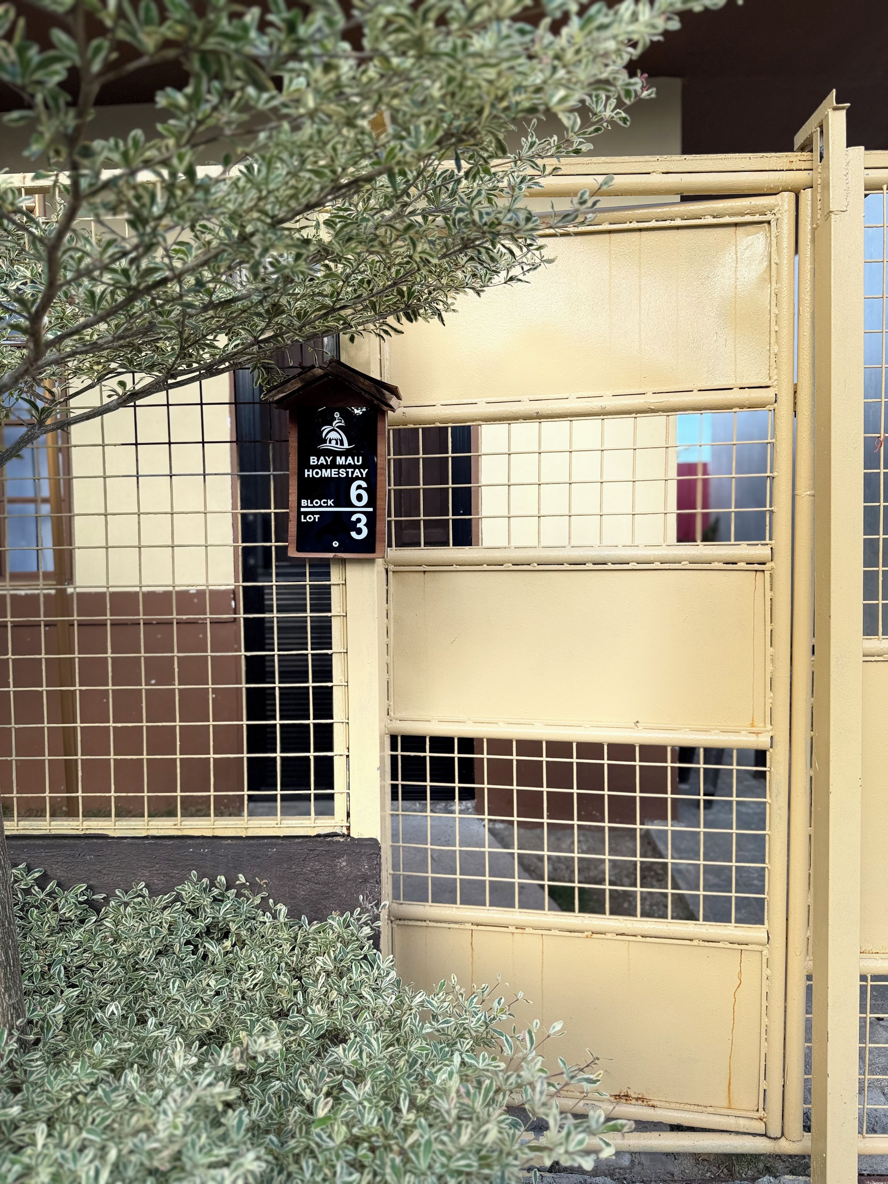 A building with a sign indicating 'Bay Mau Homestay Block 6 Lot 3.'