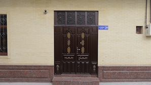 A brown double door with decorative panels and a sign above it.