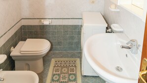 A bathroom with a toilet, bidet, sink, and a small window. - Apartments with spectacular views of Budoni Bay 3 min. from the sea-4 places (Malamurì)