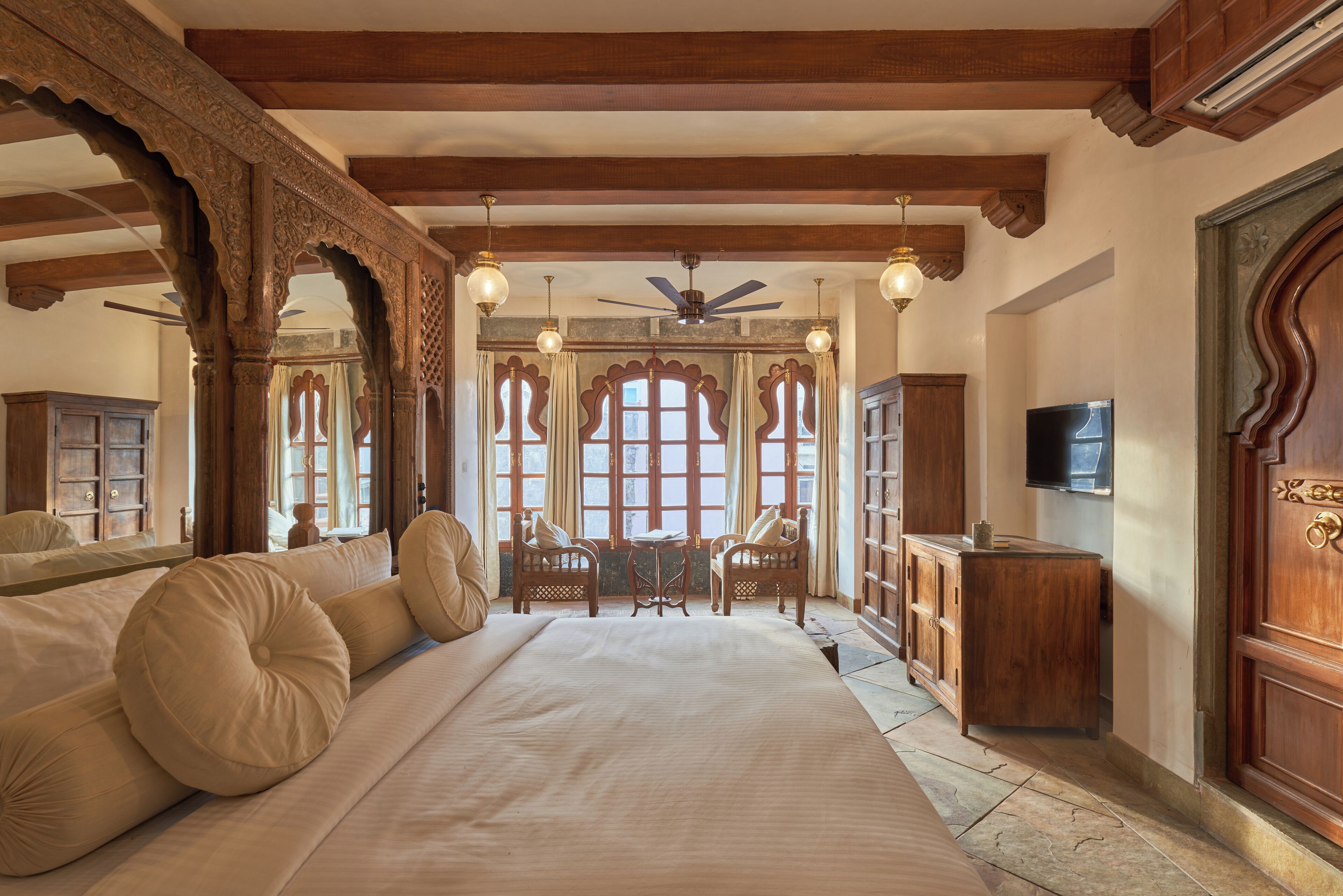 Une chambre à coucher avec un grand lit, des meubles en bois et un téléviseur.