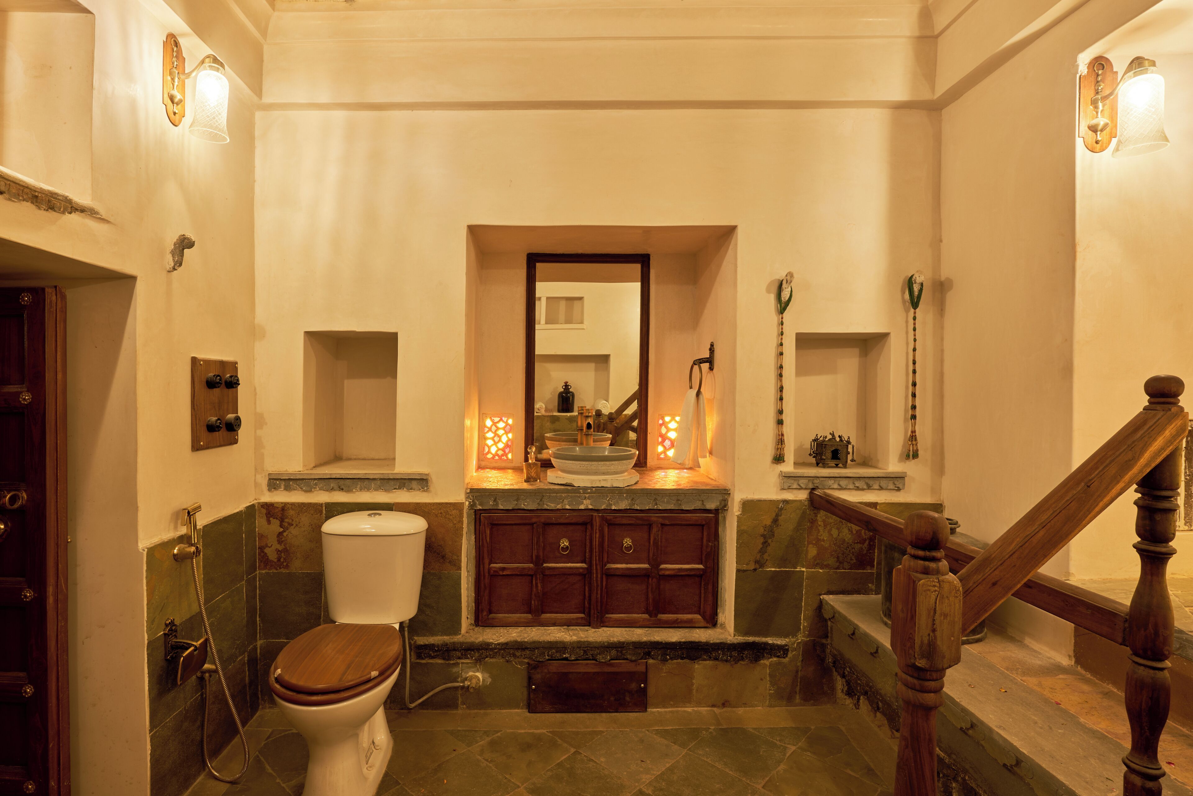 Ein Badezimmer mit Toilette aus Holz, einem Waschbecken mit Spiegel darüber und einer Duschkabine.