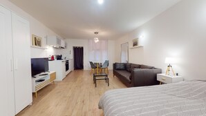 A modern hotel room with a kitchenette, a dining area, a sofa, and a bed. - Fully-equipped apartment Vieux Lyon (Lyon)