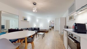 A modern, well-lit apartment with a dining area, a sofa, a bed, and a kitchenette. - Fully-equipped apartment Vieux Lyon (Lyon)