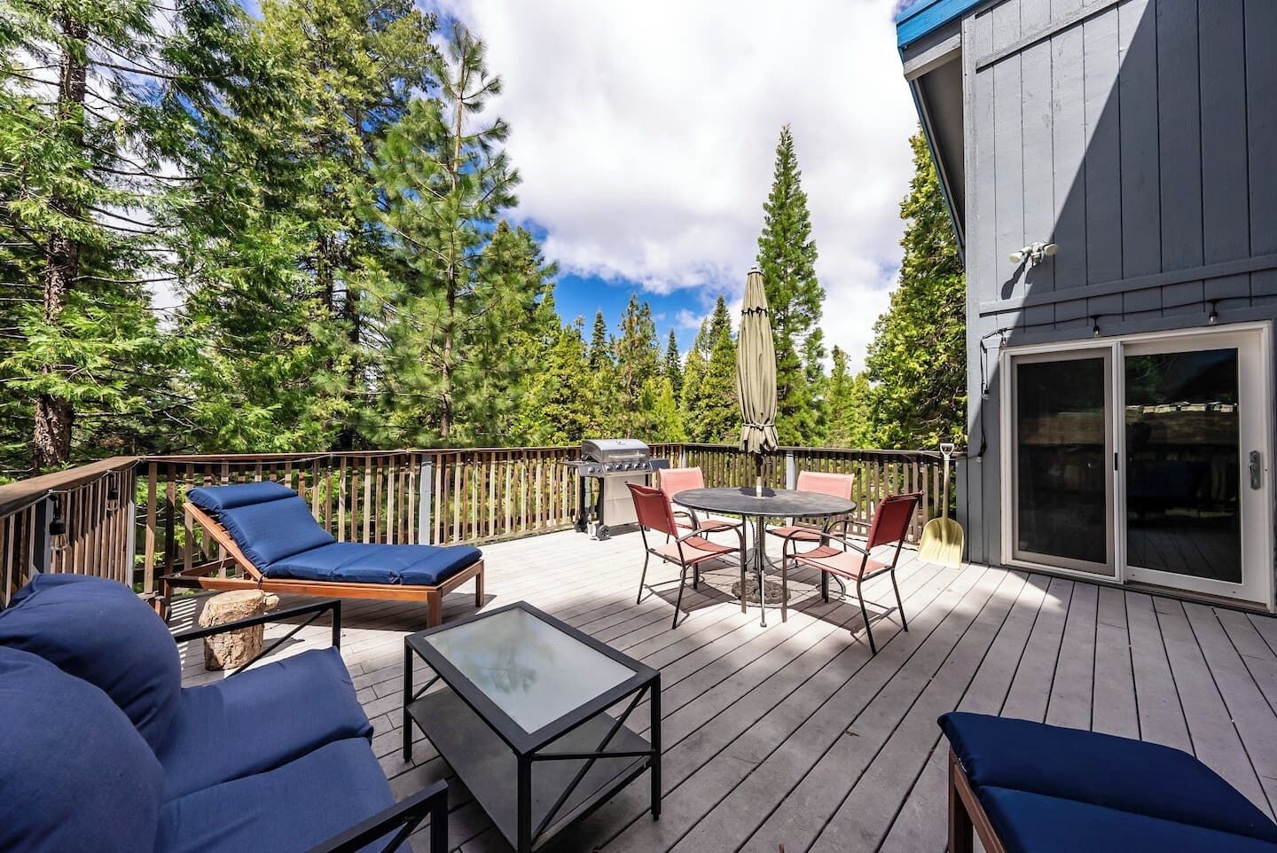 Une terrasse dotée de mobilier d’extérieur, d’un barbecue et d’une porte-fenêtre coulissante.