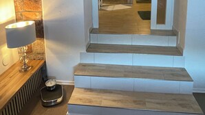 Un escalier avec un miroir qui reflète une salle de bain, une lampe et une balance.