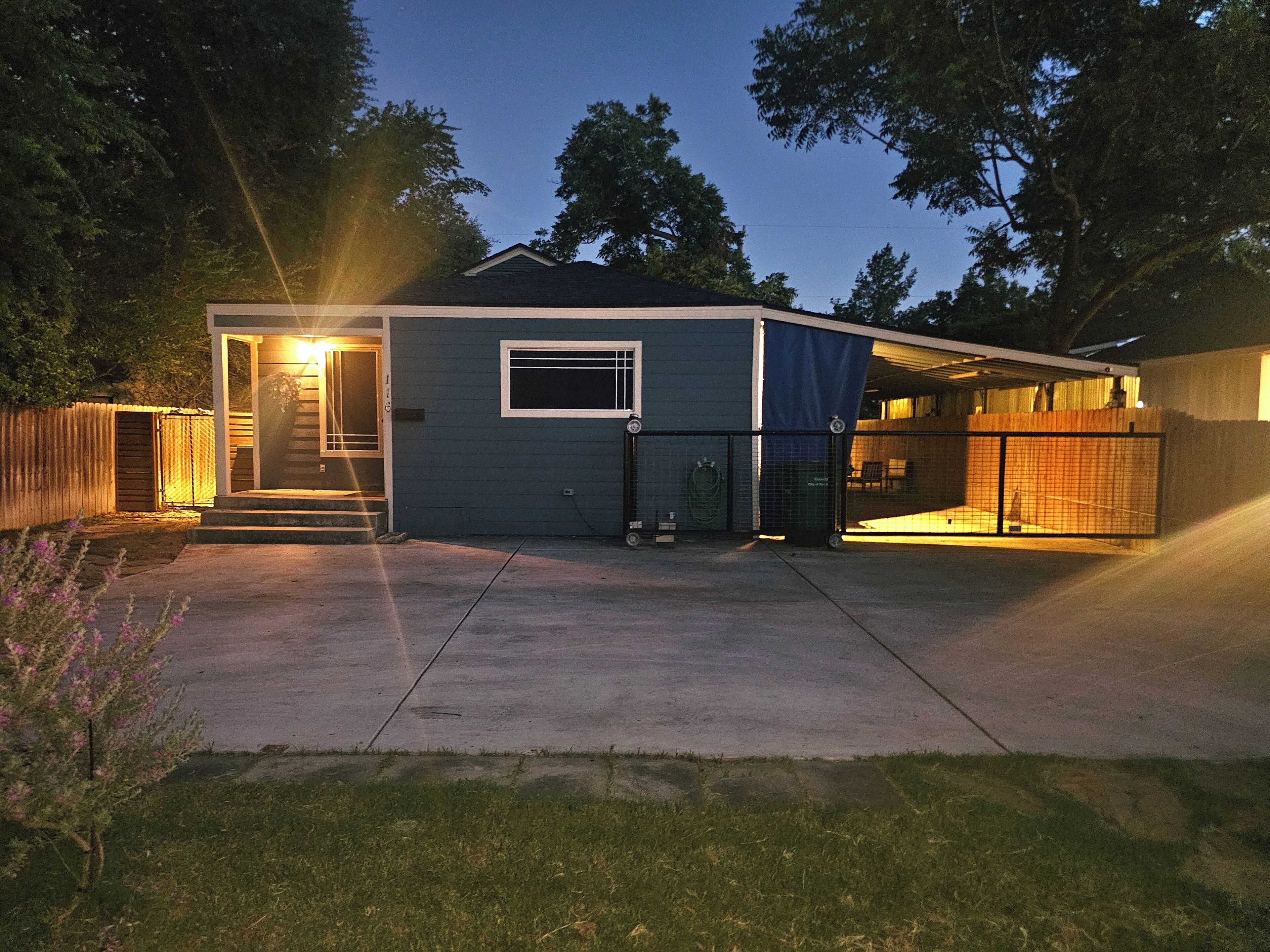 A single-story house with a front door, a small window, and a covered garage area.