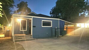 Une maison de plain-pied avec une porte d’entrée, une petite fenêtre et une porte de garage.