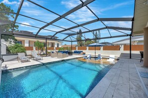 Une piscine dotée de chaises longues et d’un patio couvert.