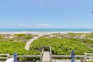 A wooden staircase leading to a beach area with a view of the ocean. - Beach Condo - Less than 75 steps from door to sand! (Cocoa Beach)