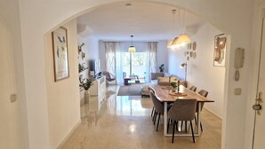 Une salle à manger spacieuse avec une longue table, des chaises et un lustre.