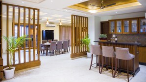A spacious living area with a dining table, chairs, a bar area, and potted plants. - Alaya Stays BYDM The Sky Heaven - 4 BHK Penthouse 15 Min from Triveni Ghat With Balcony & Lift (Rishikesh)