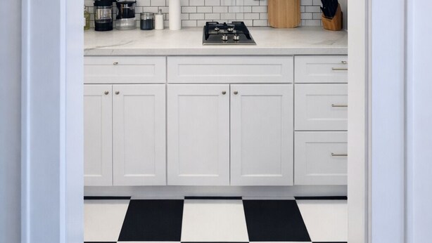 A modern kitchen with white cabinets, a stainless steel microwave, a gas stove, and a checkered floor. - Studio Downtown+HighFalls+Kitchen+TV+Unity_Pet. (Rochester)