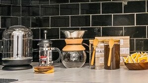 A kitchen with a coffee maker, blender, and various utensils. - Your Cozy_Studio_HighFalls_TV+Kitchen+Rochest_DT (Rochester)