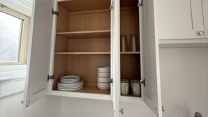 A kitchen with white cabinets, a window, a sink, and a toilet paper roll. - Modern studio in Downtown Rochester with a full kitchen and Smart TV, steps from High Falls. (Rochester)