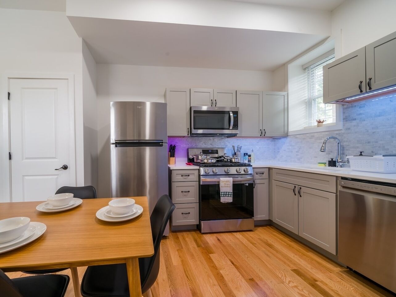 A compact kitchen with a refrigerator, microwave, stove, and sink.