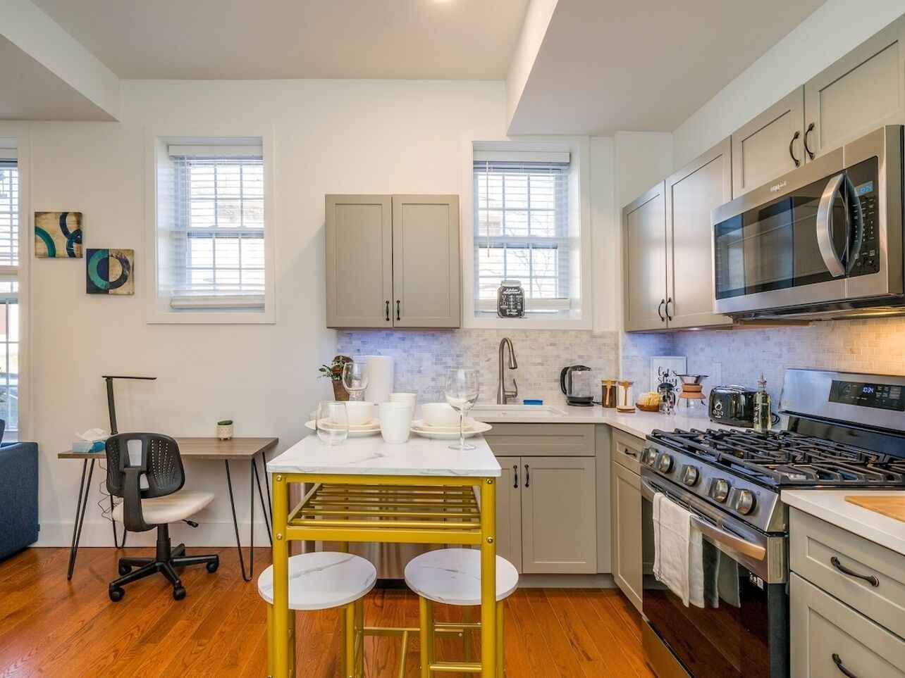 A modern kitchen with a central island, a stove, and a microwave.