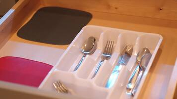 A drawer with a compartmentalized tray holding cutlery and a napkin.