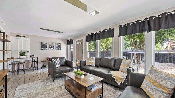 Een moderne woonkamer met een bank, salontafel en een eethoek met een tafel en stoelen.