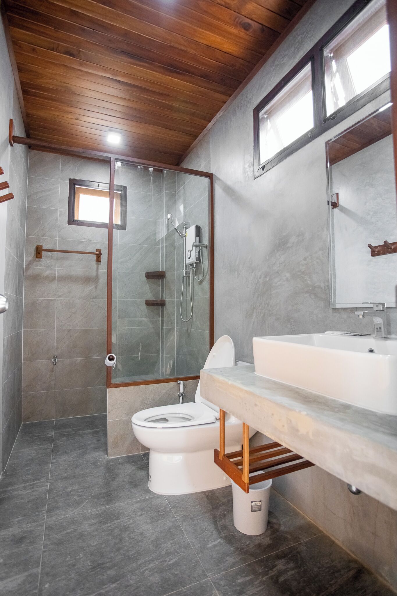 A modern bathroom with a shower, toilet, and sink.
