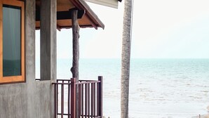 A beachfront property with a concrete structure, a wooden deck, and a view of the ocean. - Laemsui Beach (Chaiya)