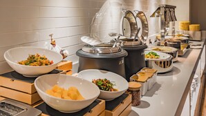 A buffet setup with various food items and containers.