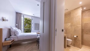 A modern bedroom with a bed, bedside table, and a view of a balcony.