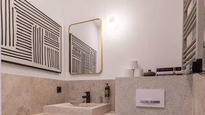Ein modernes Badezimmer mit Marmorwaschbecken, Toilette und Spiegel.