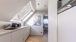 Une cuisine moderne dotée d’une verrière, d’un réfrigérateur Siemens et d’un plancher à motifs en chevrons.