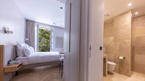 Un dormitorio moderno con cama, mesita de noche y vistas a un balcón.