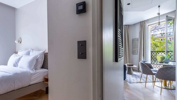 Camera d'albergo moderna con un letto, una scrivania e vista sulla città.